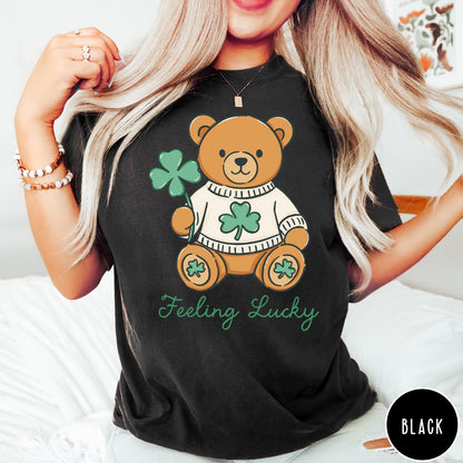 Comfort Colors tee in Black featuring illustrated teddy bear wearing a sweater and holding a four-leaf clover