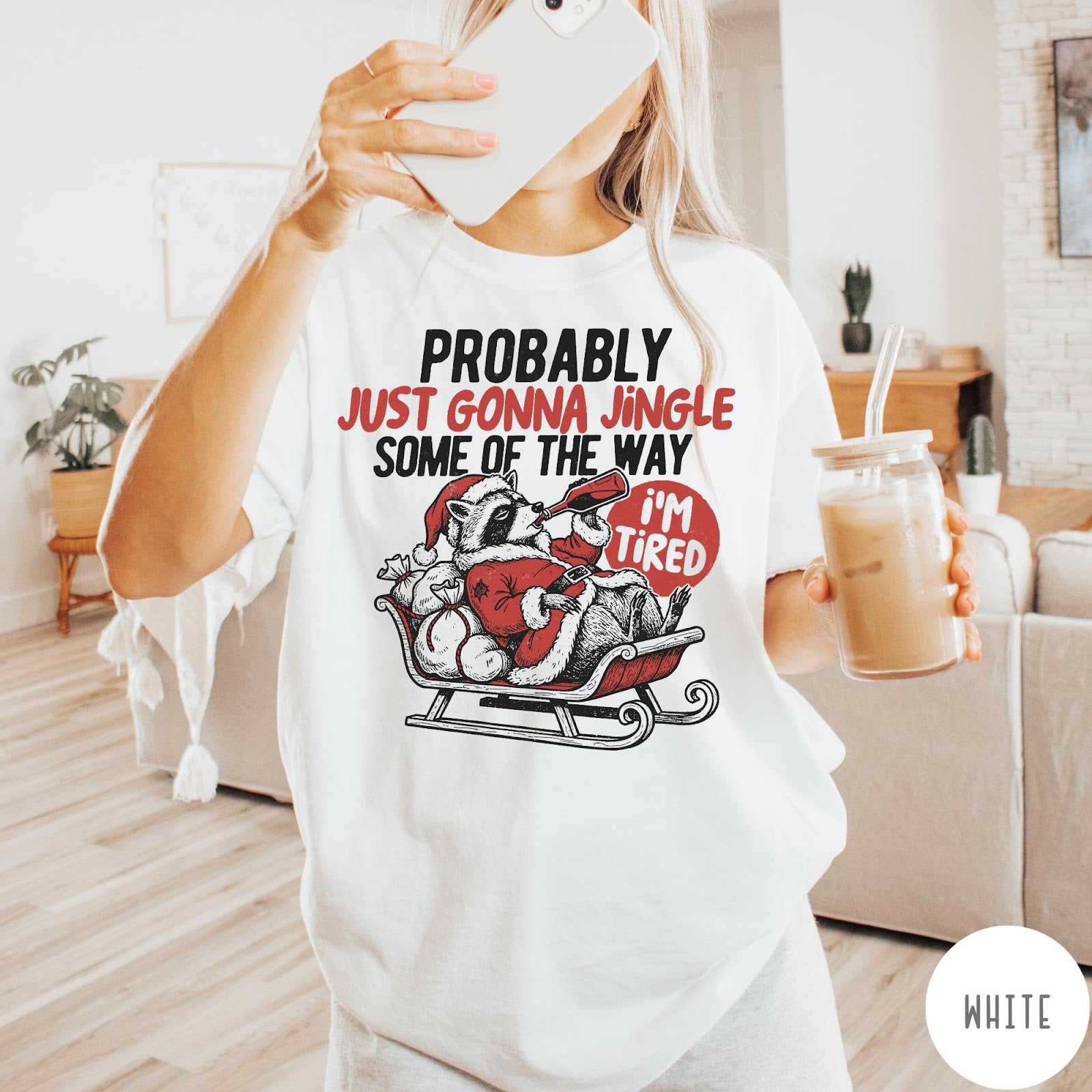 Comfort Colors tee in White featuring vintage style graphic of a tired raccoon in a Santa sleigh