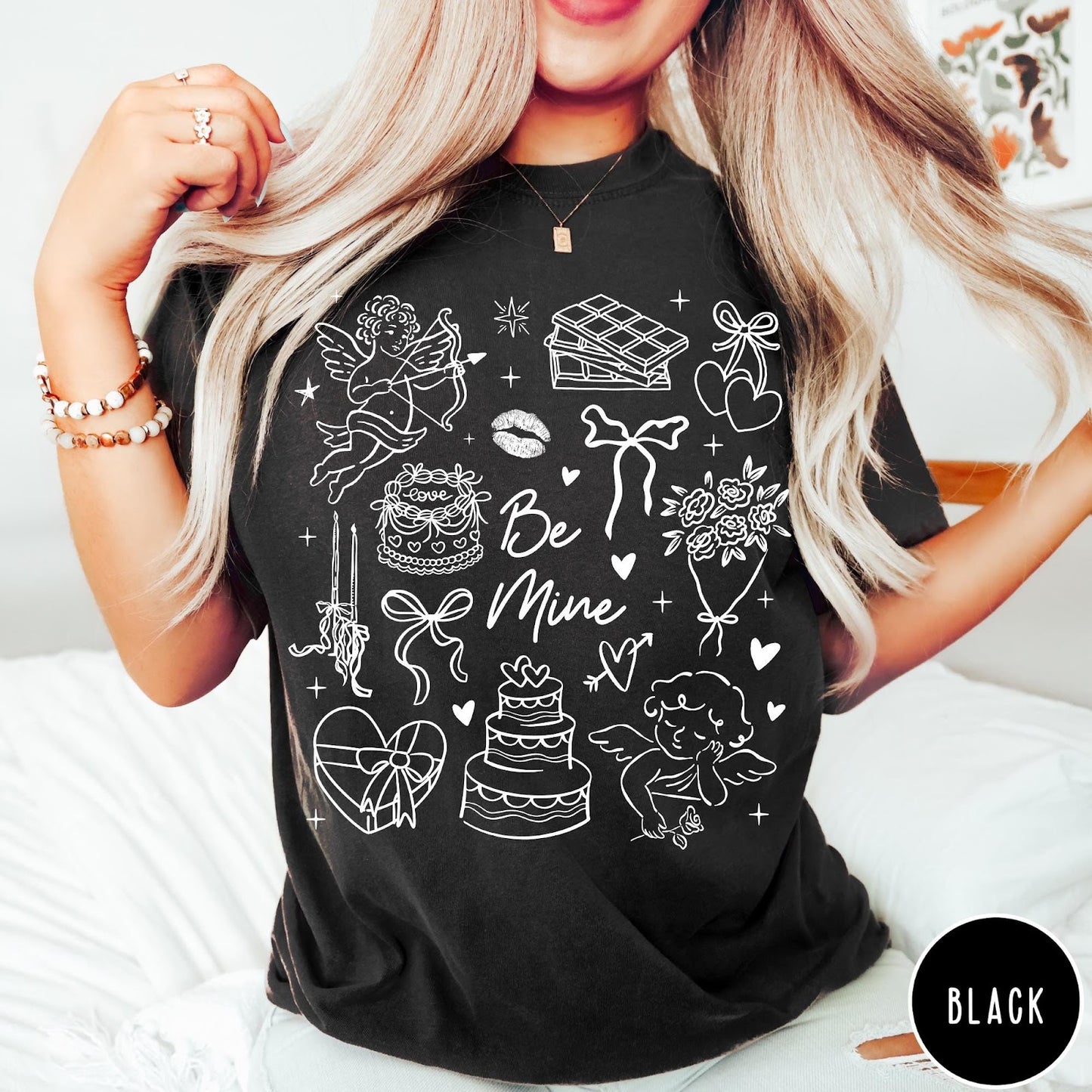 Comfort Colors tee in Black featuring Valentine's Day collage graphic with cupid, cakes, and romantic symbols.