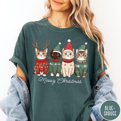 Comfort Colors tee in Blue Spruce featuring holiday graphic of four cats wearing Christmas sweaters and hats
