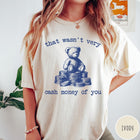 Comfort Colors tee in Ivory featuring graphic style teddy bear sitting on a stack of coins
