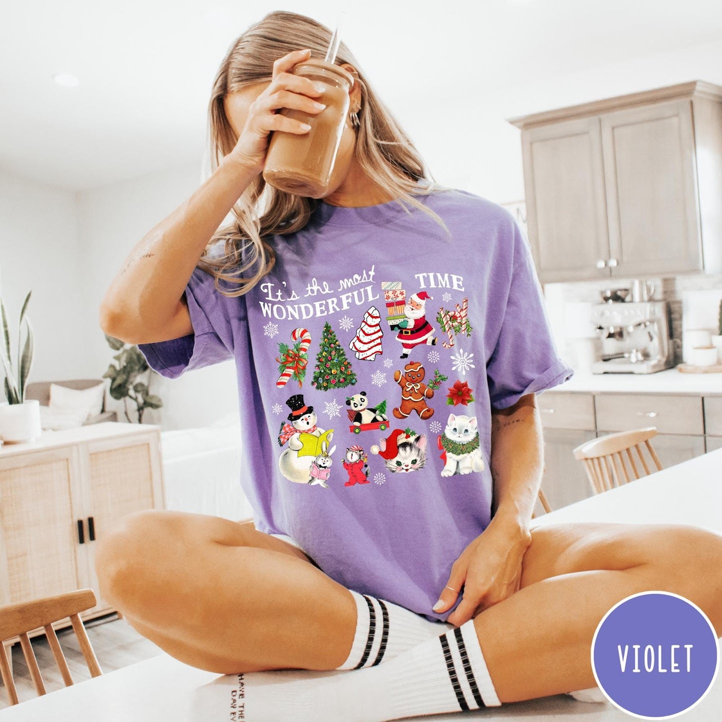Comfort Colors tee in Violet featuring Christmas collage graphic with Santa, snowman, animals, and holiday icons