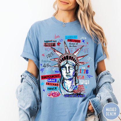 Comfort Colors tee in Washed Denim featuring grunge style Statue of Liberty graphic with patriotic red and blue text