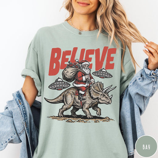 Comfort Colors tee in Bay featuring vintage style graphic of Santa riding a dinosaur with flying saucers