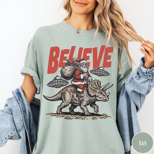 Comfort Colors tee in Bay featuring vintage style graphic of Santa riding a dinosaur with flying saucers