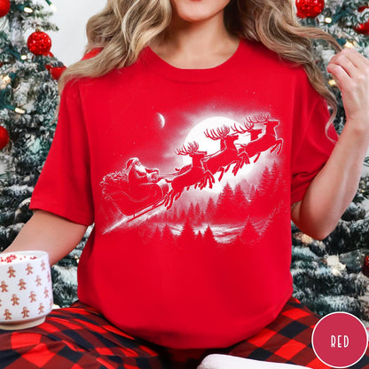 Comfort Colors tee in Red featuring vintage style Santa Claus flying in a sleigh with reindeer