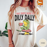 Comfort Colors tee in Ivory featuring illustrative style graphic of a frog sitting on a mushroom drinking tea