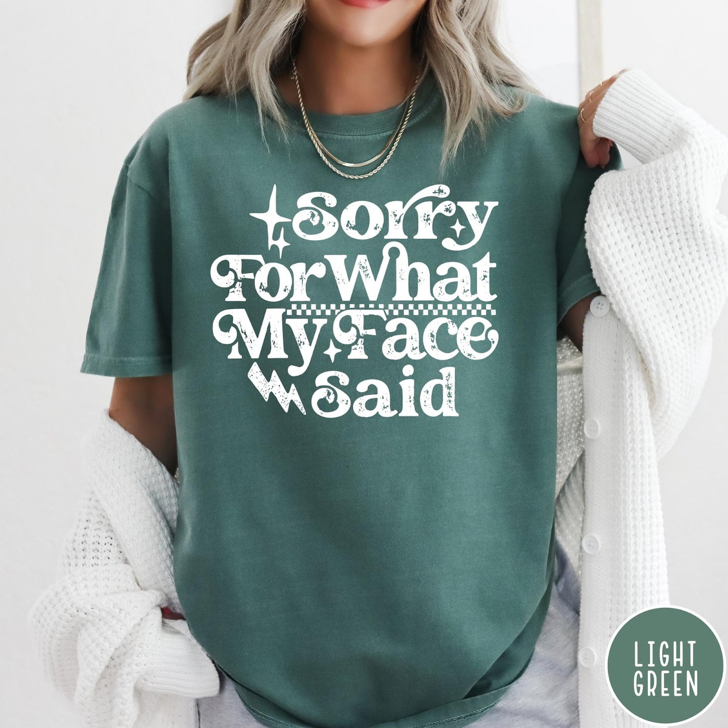 Comfort Colors tee in Light Green featuring sarcastic expression graphic Sorry for What My Face Said in white