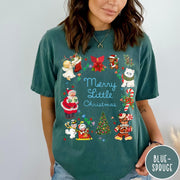 Comfort Colors tee in Blue Spruce featuring vintage style holiday characters including Santa, a snowman, and gingerbread man.