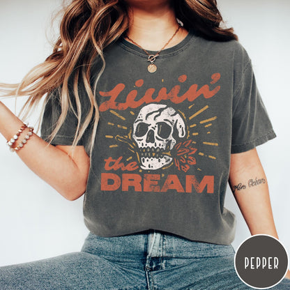 Comfort Colors tee in Pepper featuring vintage style skull graphic with Livin the Dream text design