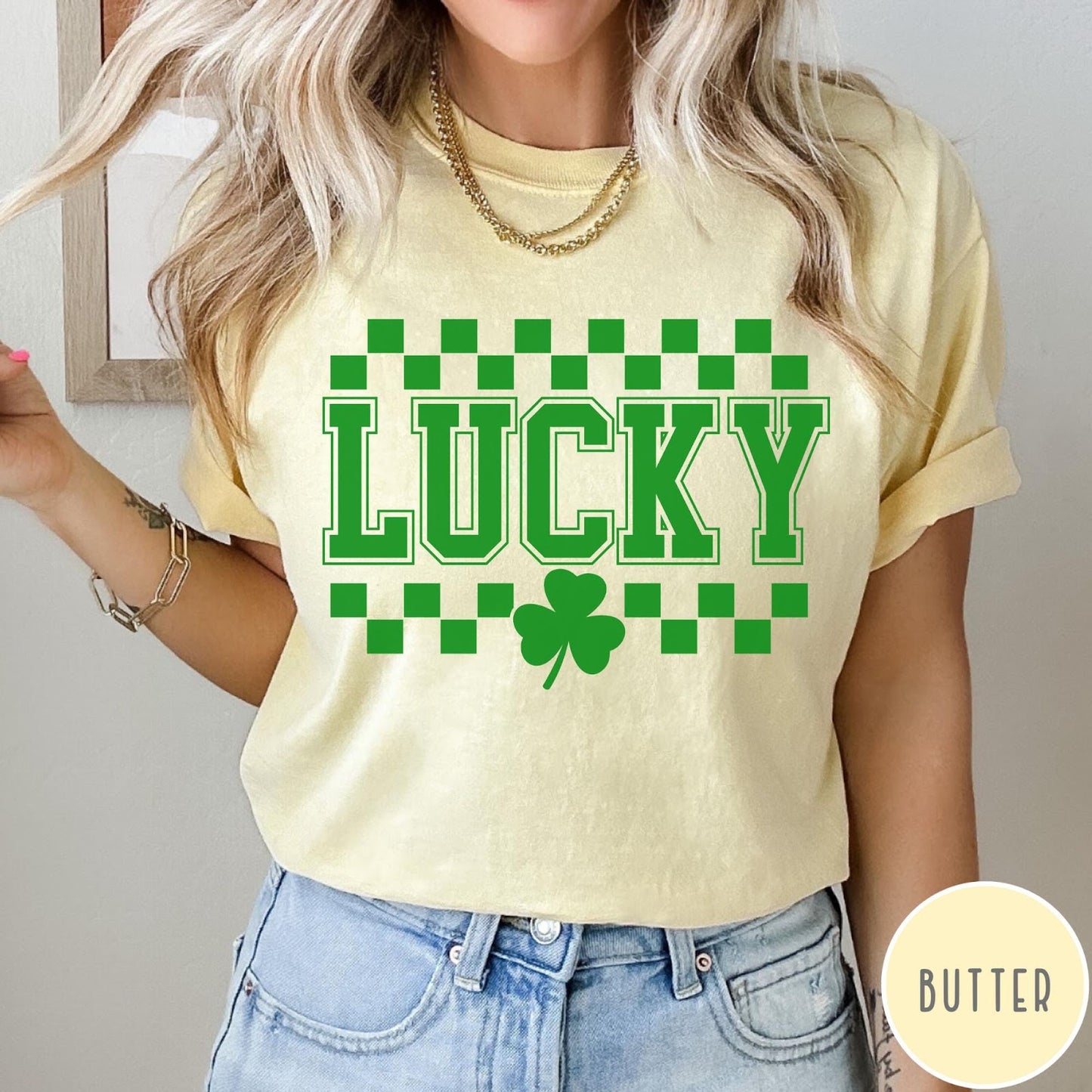Comfort Colors tee in Butter featuring checkerboard design with Lucky text and a shamrock graphic