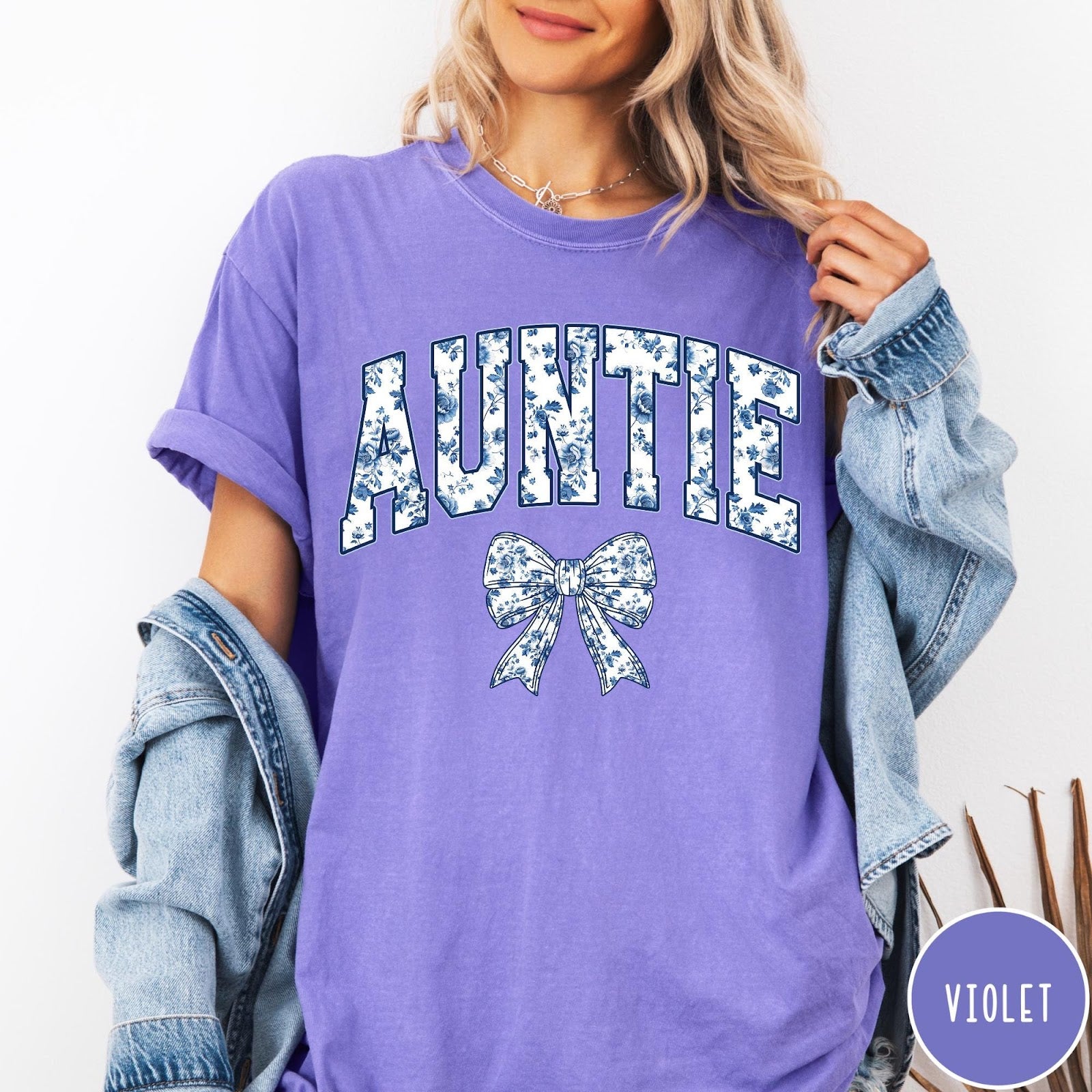 Comfort Colors tee in Violet featuring floral bow graphic with the word Auntie in blue floral print