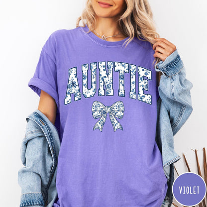 Comfort Colors tee in Violet featuring floral bow graphic with the word Auntie in blue floral print