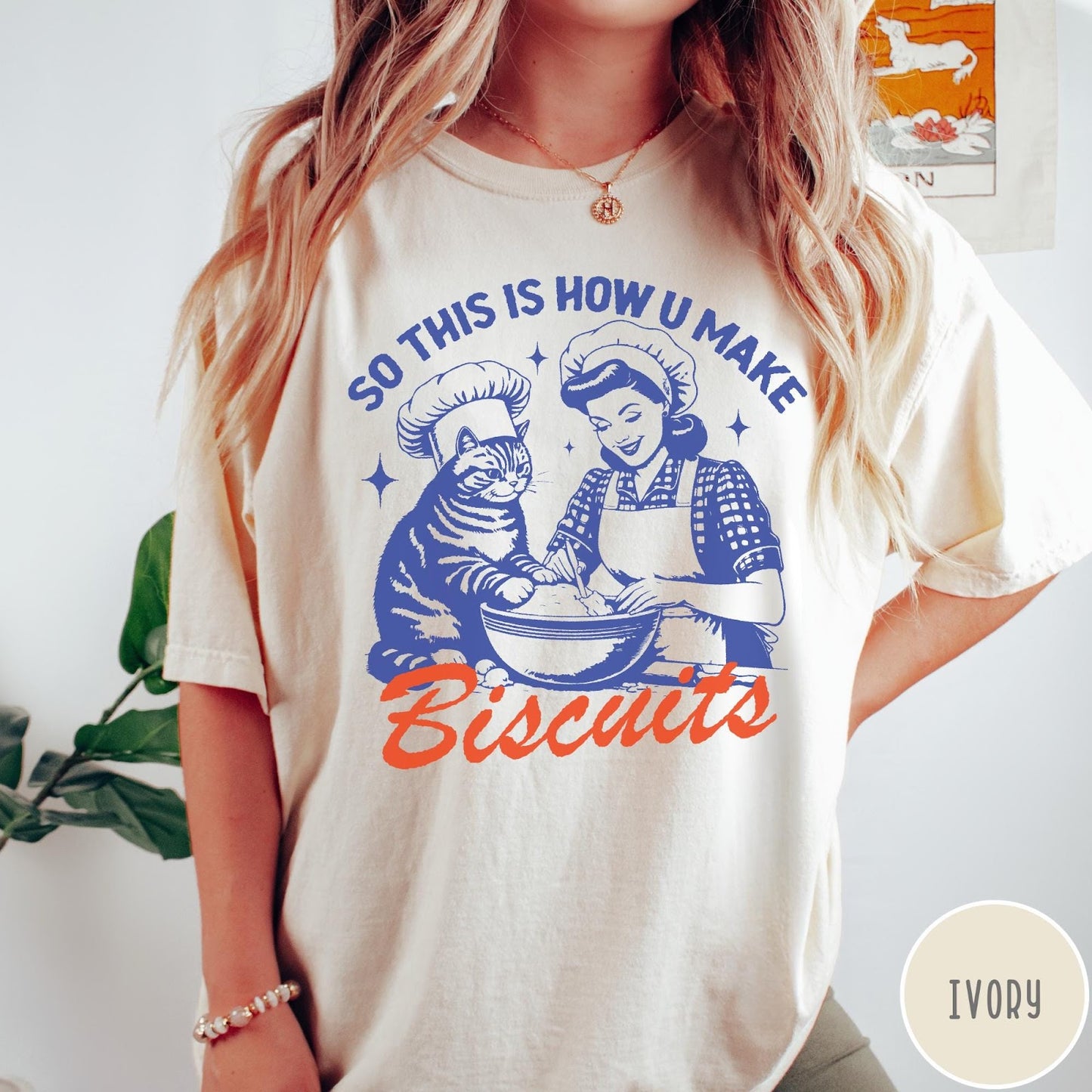 Comfort Colors tee in Ivory featuring vintage style graphic of a woman and cat baking biscuits together