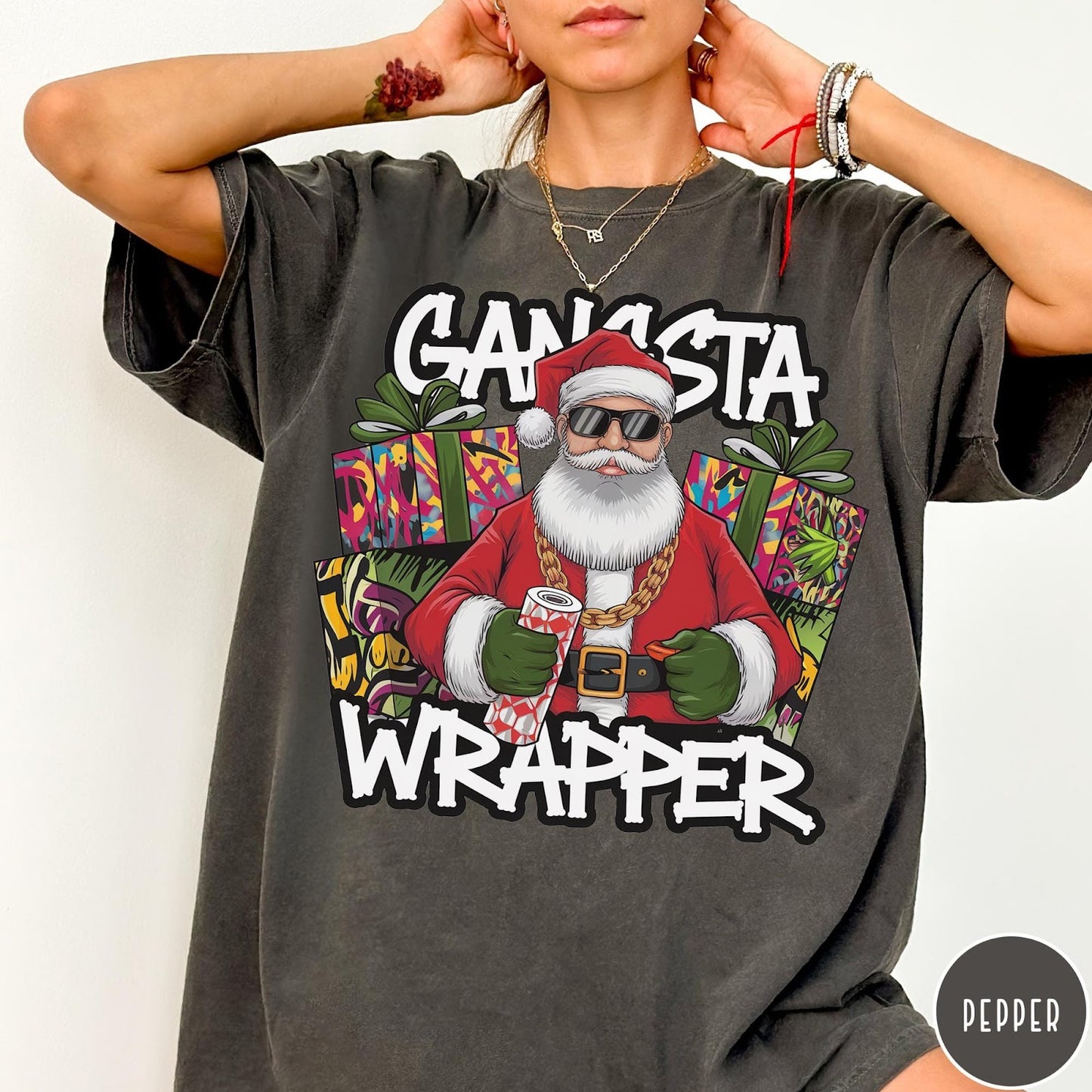 Comfort Colors tee in Pepper featuring cartoon style Santa Claus wearing sunglasses and gold chain holding wrapping paper