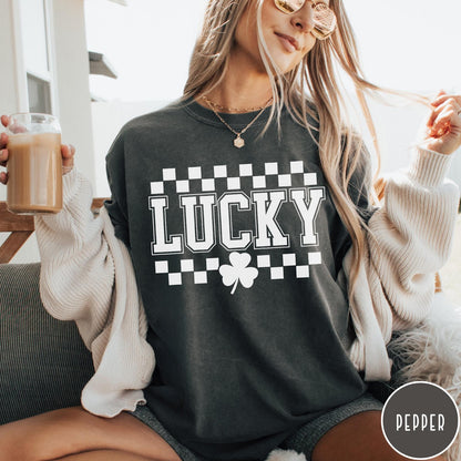 Comfort Colors tee in Pepper featuring checkerboard design with Lucky text and a shamrock graphic