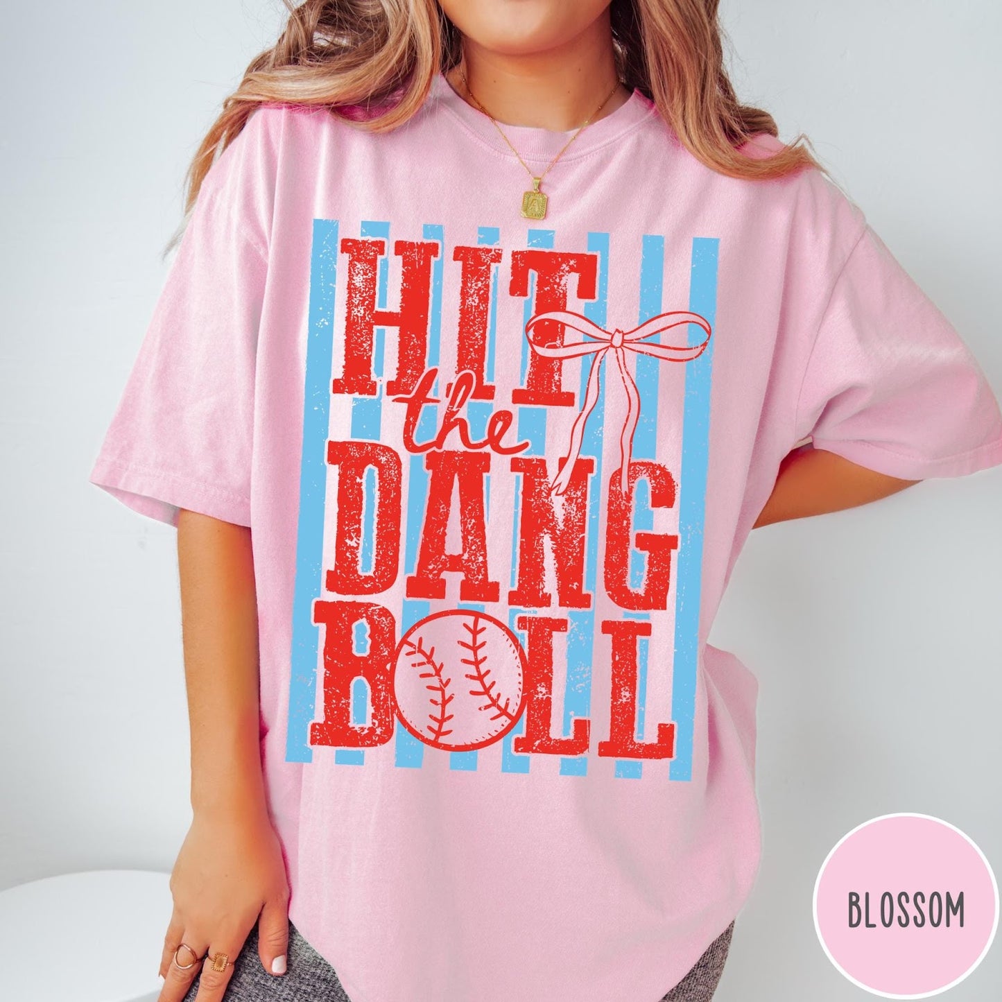 Comfort Colors tee in Blossom featuring baseball graphic with red text and blue stripes and a bow