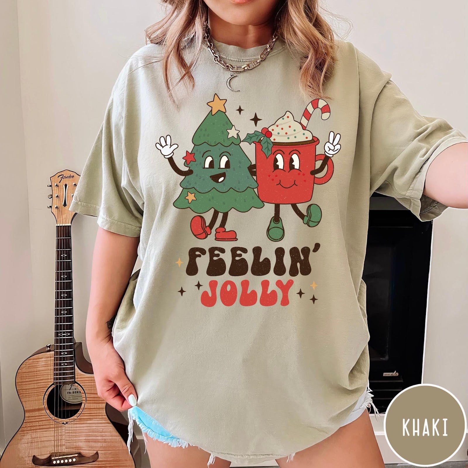 Comfort Colors tee in Khaki featuring retro graphic of a smiling Christmas tree and cocoa mug