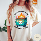 Comfort Colors tee in Ivory featuring cartoon style graphic of a smiling dumpster fire with text