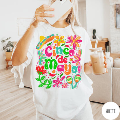 Comfort Colors tee in White featuring festive Cinco de Mayo graphic with sombrero, maracas, and colorful flowers