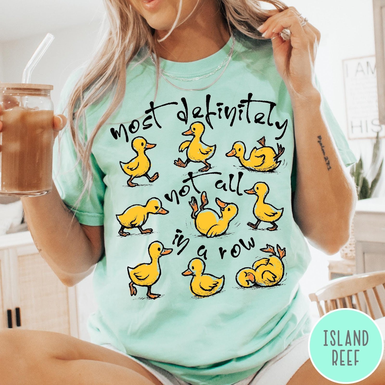Comfort Colors tee in Island Reef featuring screen print style graphic of nine yellow ducks in various poses