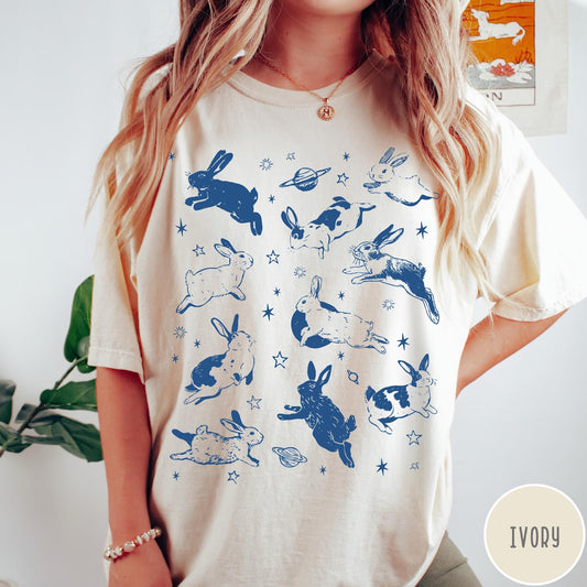 Comfort Colors tee in Ivory featuring celestial design style with jumping bunnies and planets graphic print