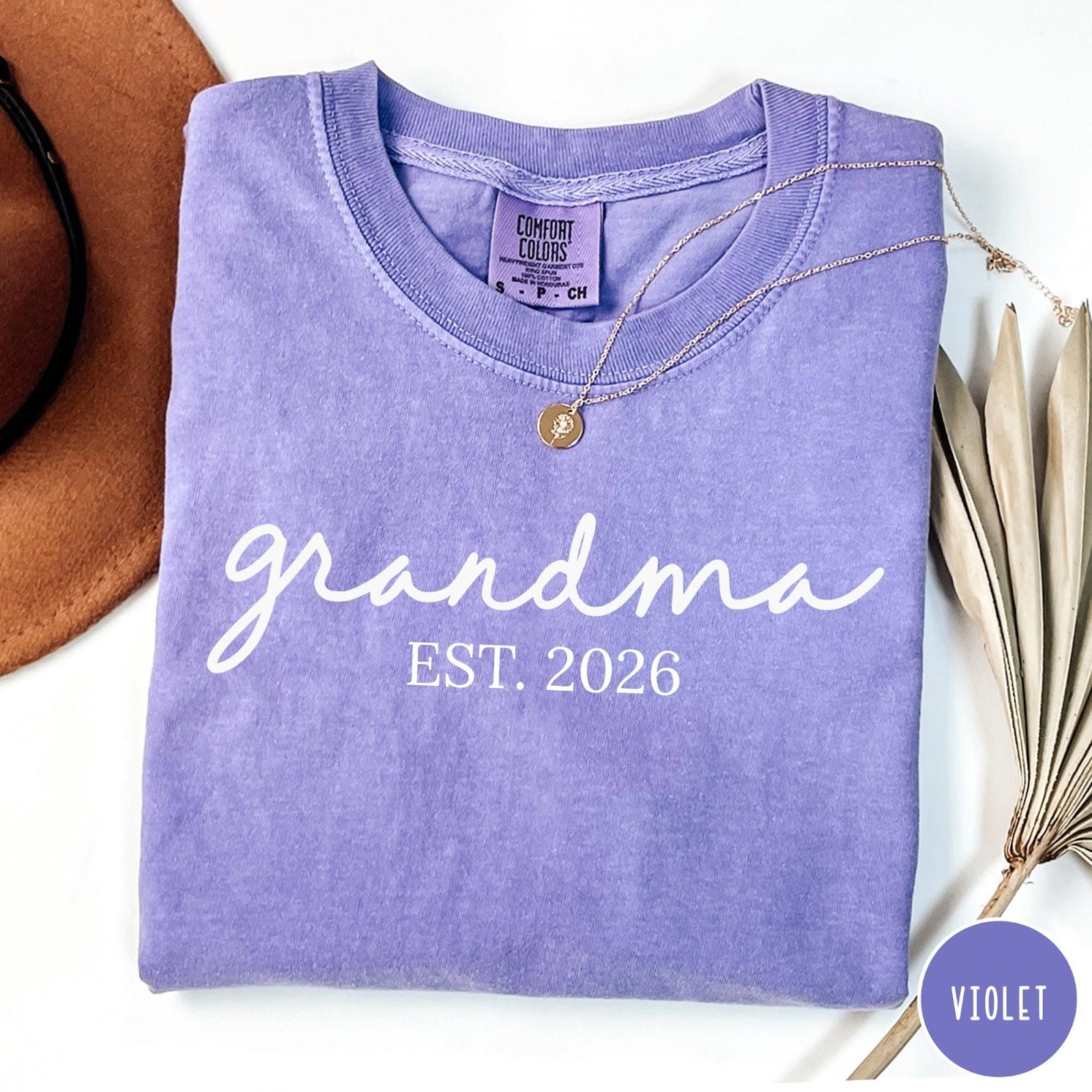 Comfort Colors tee in Violet featuring cursive Grandma Est 2026 text in a clean white graphic style