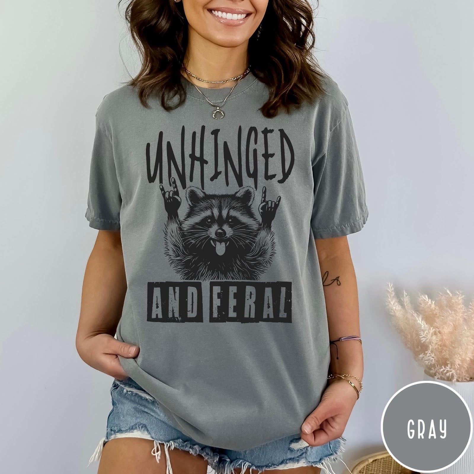 Comfort Colors tee in Gray featuring graphic style raccoon with tongue out and rock and roll hands