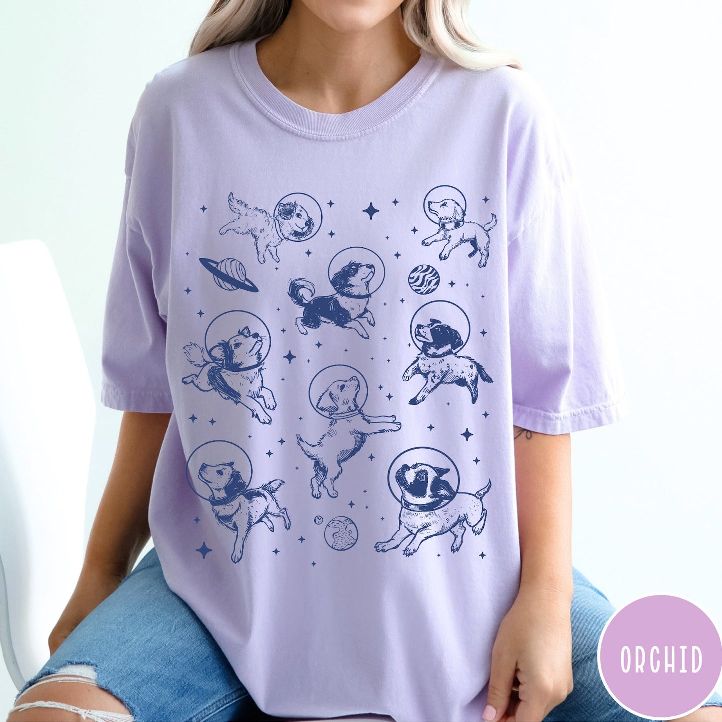 Comfort Colors tee in Orchid featuring space theme graphic with various dogs wearing astronaut helmets and planets