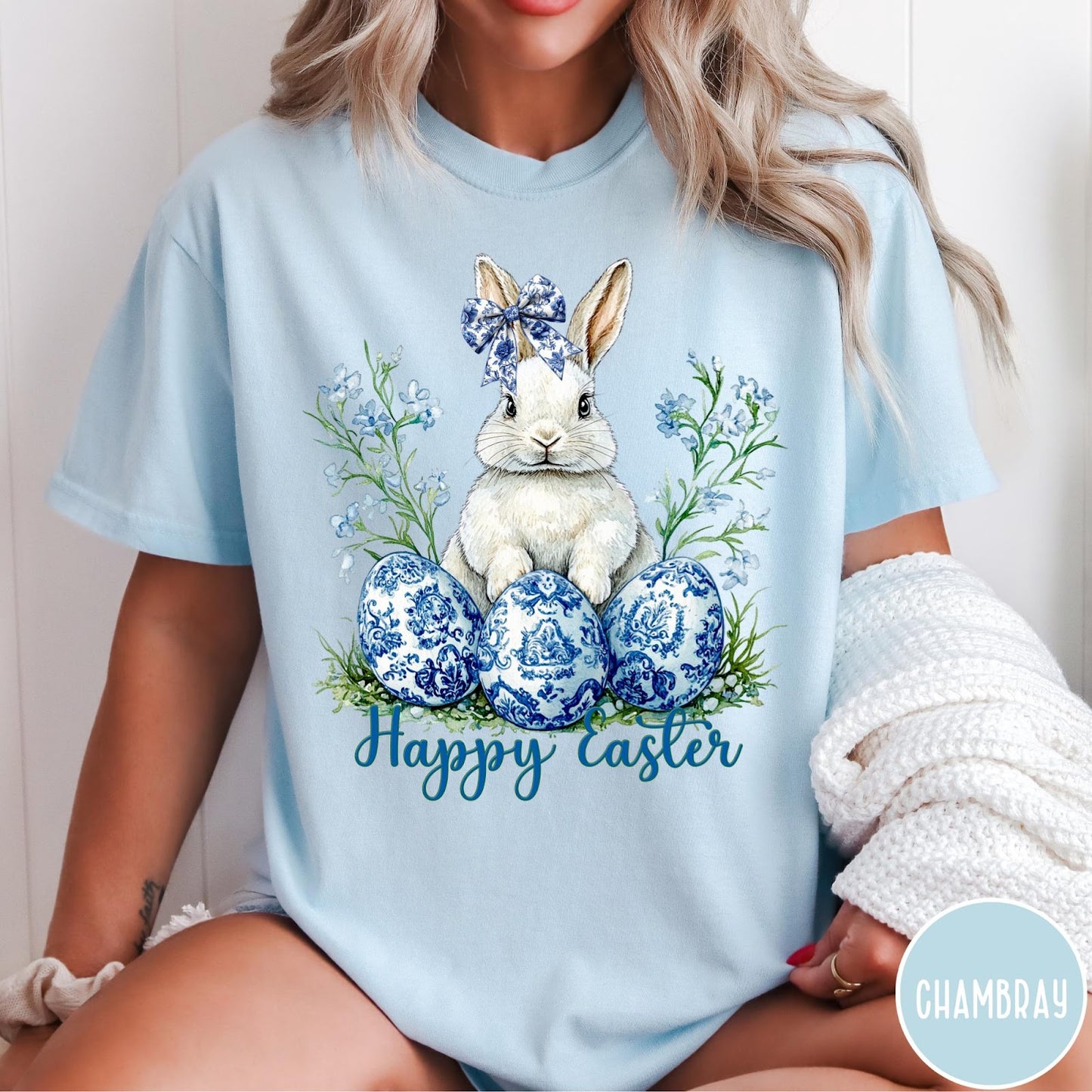 Comfort Colors tee in Chambray featuring Easter bunny graphic with blue floral bow and patterned Easter eggs