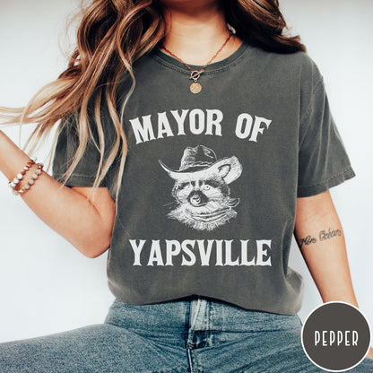 Comfort Colors tee in Pepper featuring western style graphic of a raccoon wearing a cowboy hat and bandana