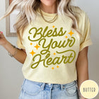 Comfort Colors tee in Butter featuring script lettering and star accents with the phrase Bless Your Heart