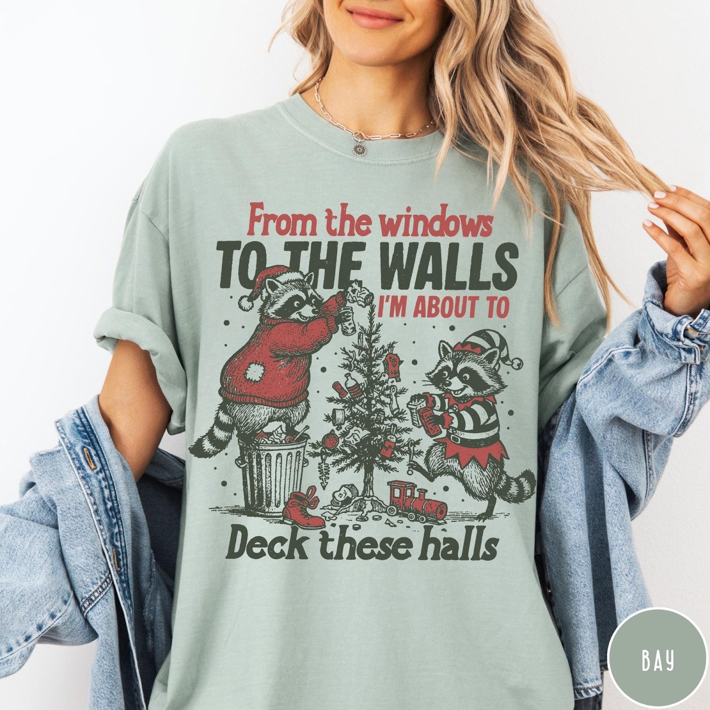 Comfort Colors tee in Bay featuring festive raccoon graphic with Christmas tree and holiday themed text design