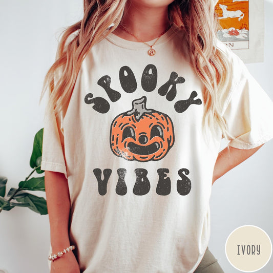 Comfort Colors tee in Ivory featuring retro style graphic with a smiling pumpkin and Spooky Vibes text
