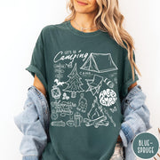 Comfort Colors tee in Blue Spruce featuring retro camping adventure collage graphic with tent, campfire, and outdoor icons