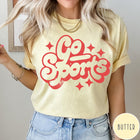 Comfort Colors tee in Butter featuring retro sports style graphic with Go Sports text and star accents