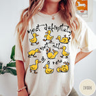 Comfort Colors tee in Ivory featuring screen print style graphic of nine yellow ducks in various poses