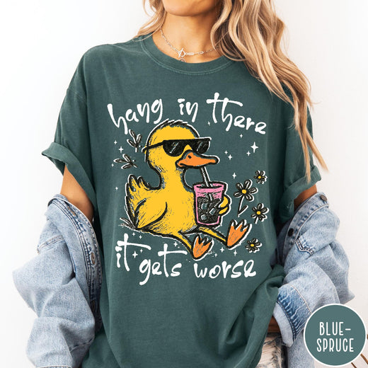 Comfort Colors tee in Blue Spruce featuring illustrated duck graphic wearing sunglasses and drinking a pink iced beverage