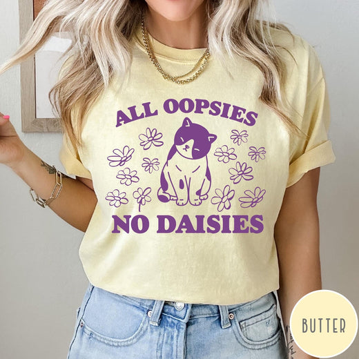 Comfort Colors tee in Butter featuring cute cat graphic with purple text reading All Oopsies No Daisies