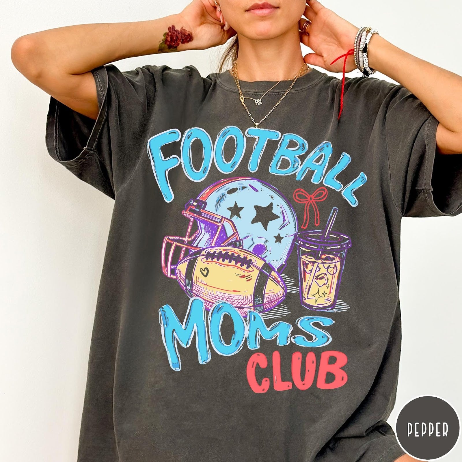 Comfort Colors tee in Pepper featuring football lifestyle graphic with helmet, football, and iced coffee drink design