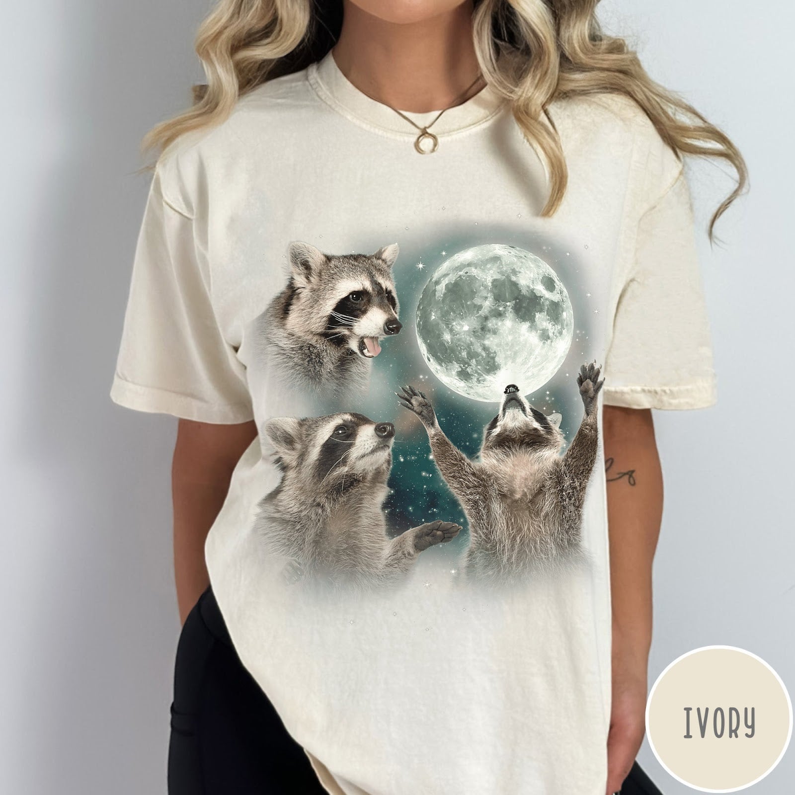 Comfort Colors tee in Ivory featuring artistic graphic of three raccoons reaching toward a bright full moon