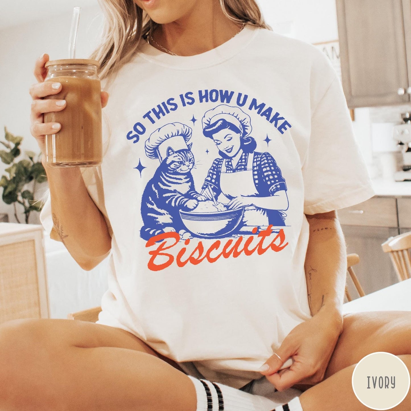 Comfort Colors tee in Ivory featuring vintage style graphic of a woman and cat baking biscuits together