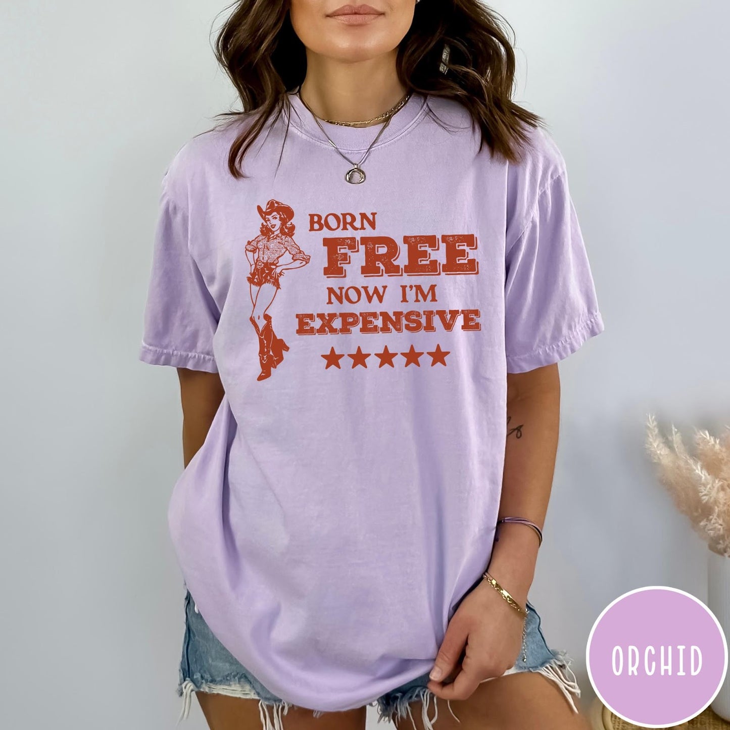 Comfort Colors tee in Orchid featuring cowgirl design with Born Free Now I'm Expensive text and stars