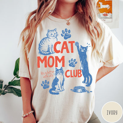 Comfort Colors tee in Ivory featuring graphic illustration of cats, paw prints, and Cat Mom Club text