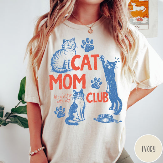 Comfort Colors tee in Ivory featuring graphic illustration of cats, paw prints, and Cat Mom Club text