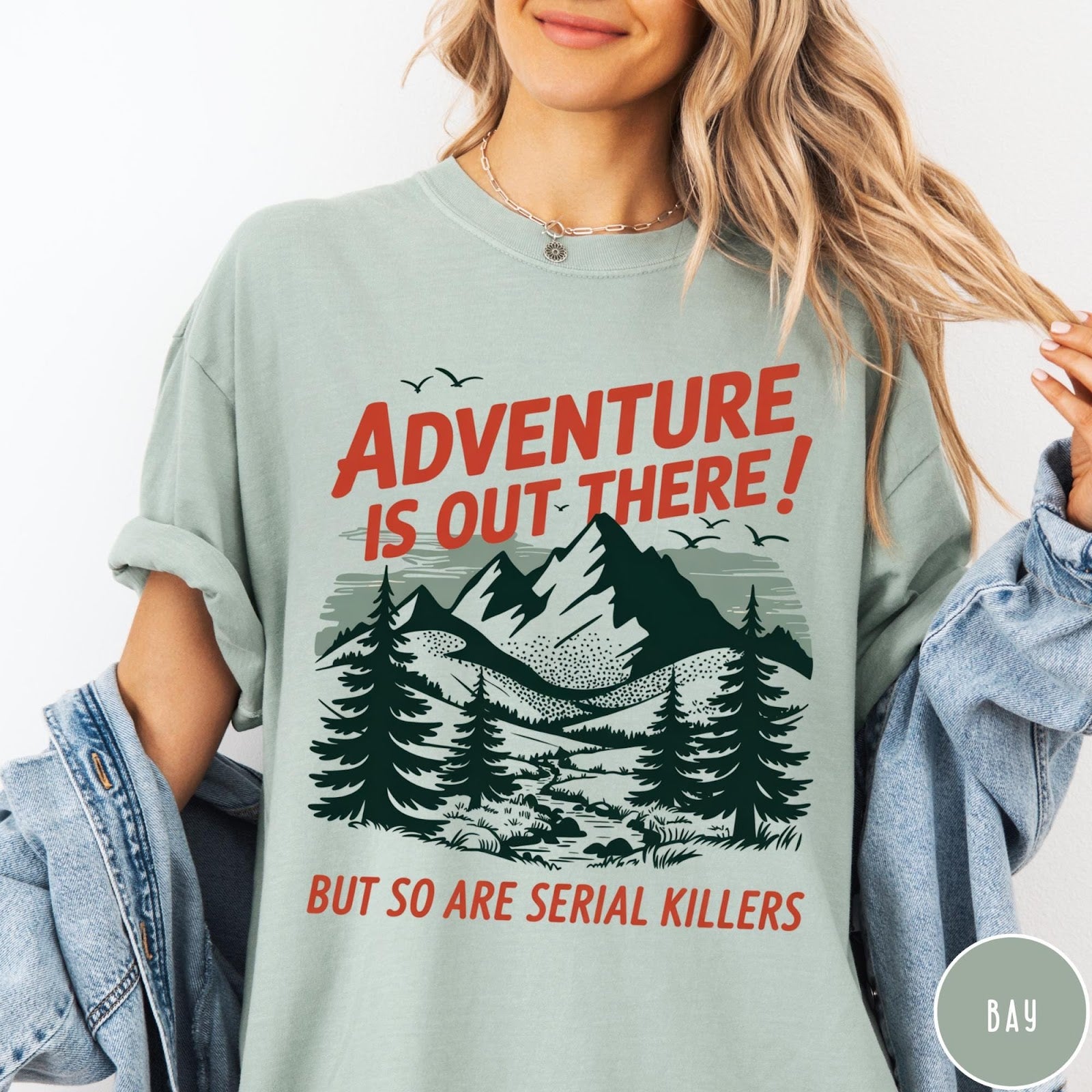 Comfort Colors tee in Bay featuring mountain and tree graphic with adventure and serial killer text design