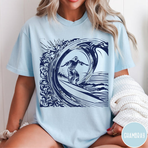 Comfort Colors tee in Chambray featuring graphic style Jesus surfing on a large ocean wave