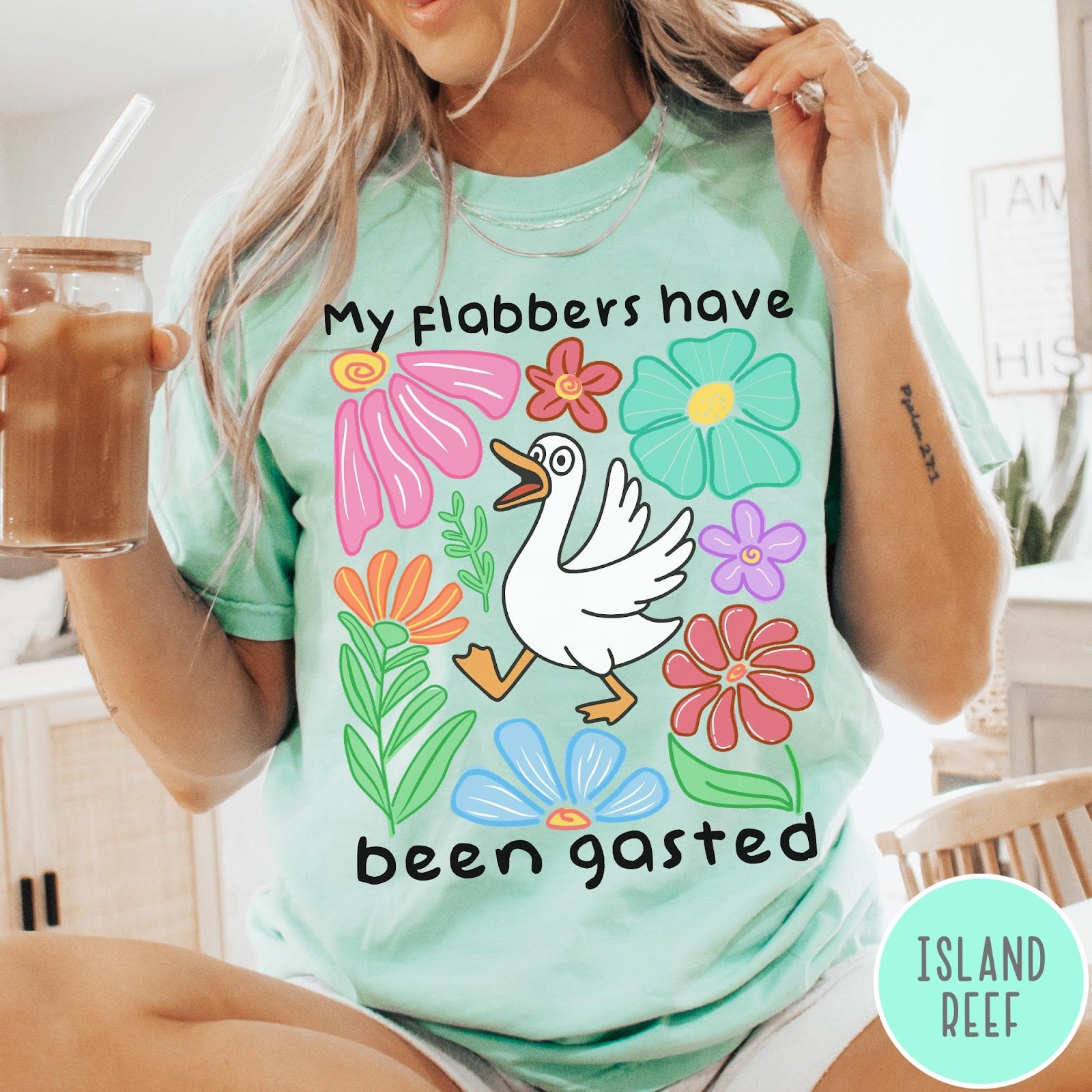 Comfort Colors tee in Island Reef featuring playful cartoon style graphic of a goose surrounded by colorful flowers