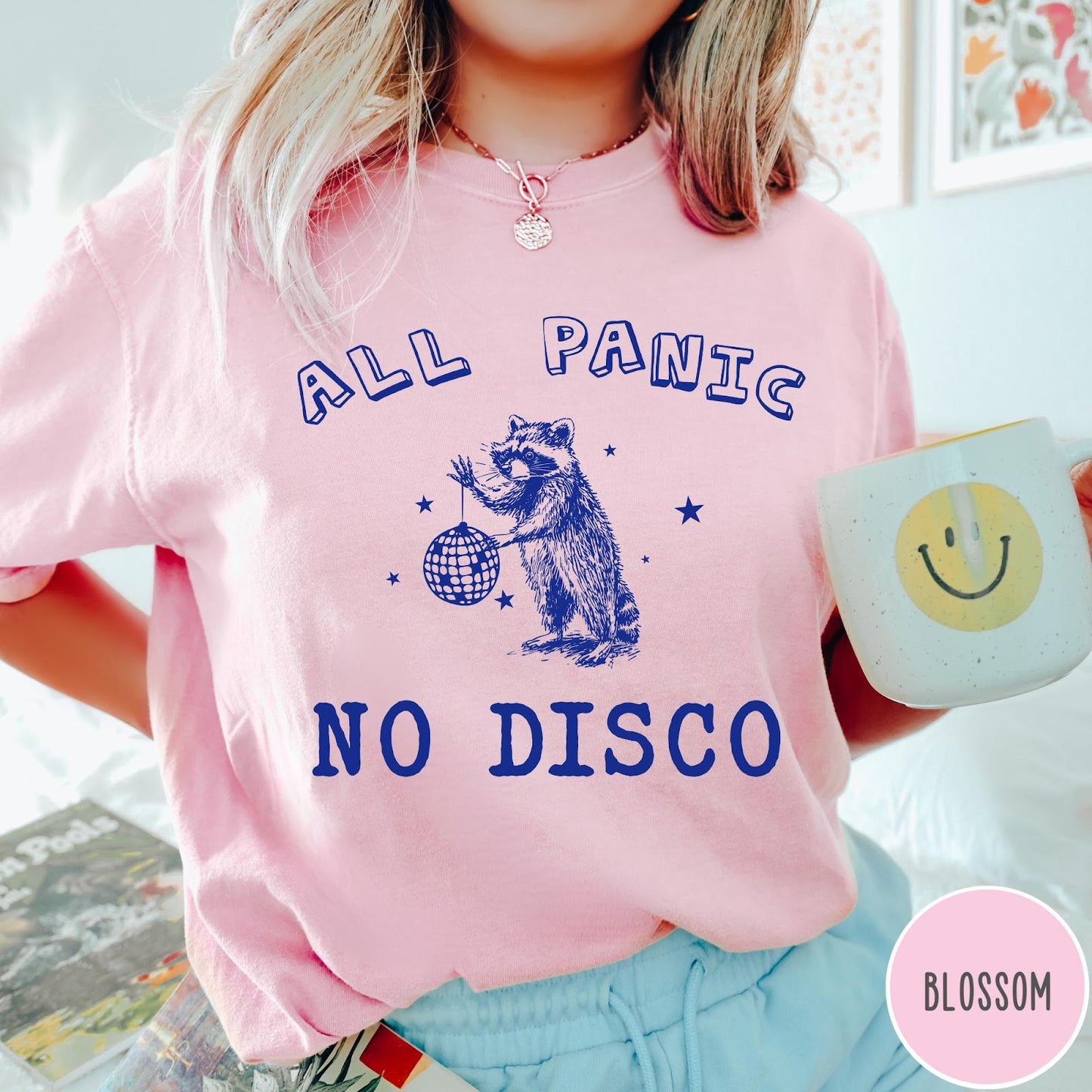 Comfort Colors tee in Blossom featuring screen printed raccoon graphic holding a disco ball with star accents