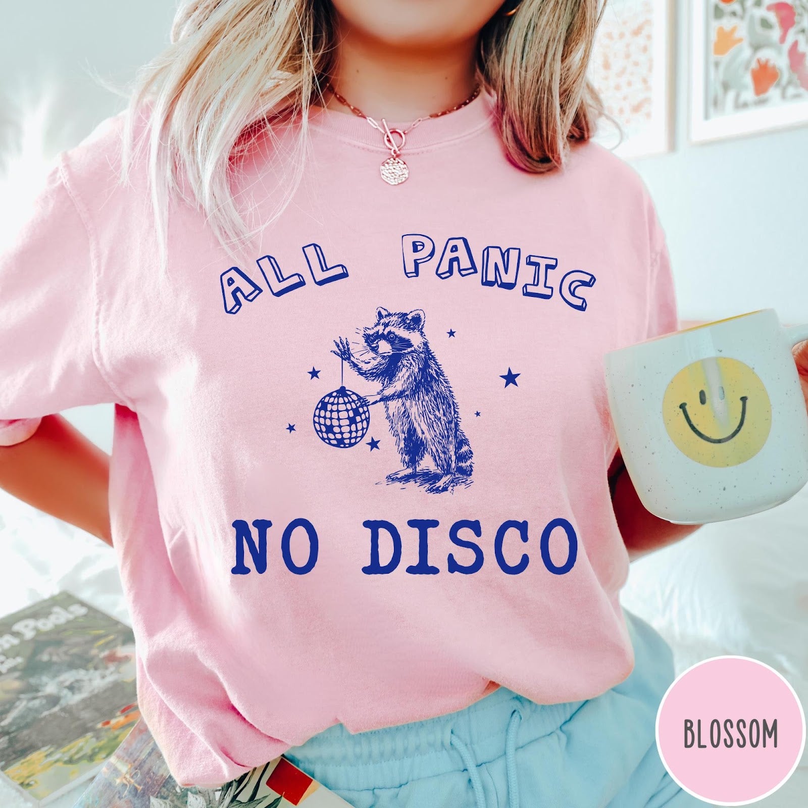 Comfort Colors tee in Blossom featuring screen printed raccoon graphic holding a disco ball with star accents